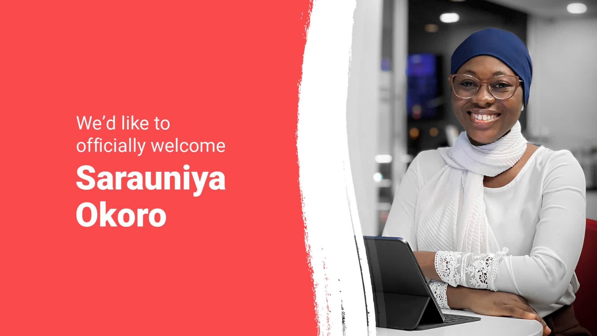 Smiling woman at a desk with a laptop, being welcomed with her name, sarauinya okoro.