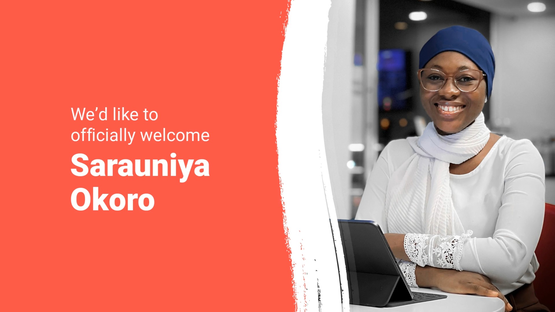 Woman in hijab smiling at camera, seated at desk with laptop, Biteable video maker graphic welcoming sarauniya okoro.