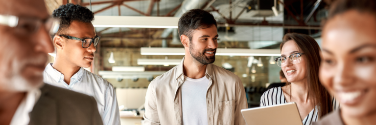 A diverse group of professionals engaging in a discussion while walking through a modern office space.